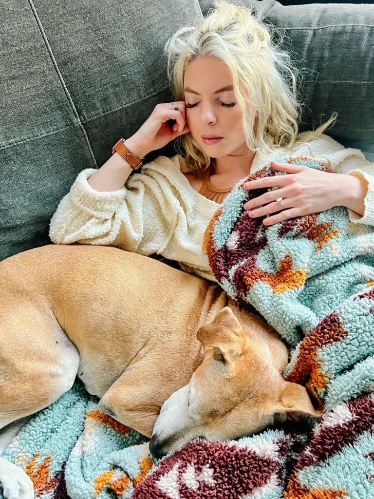 A girl napping on the couch with her dog because depression makes her feel sleeepy